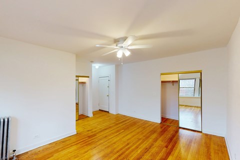 A room with wooden floors and a ceiling fan.