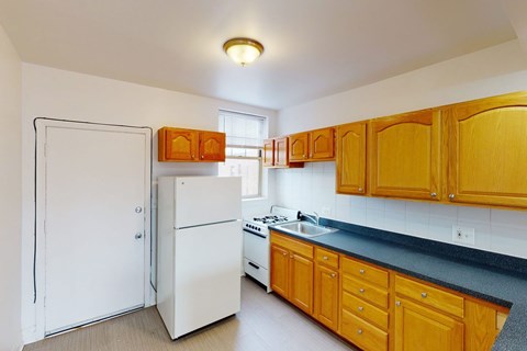 A kitchen with wooden cabinets and a white fridge.