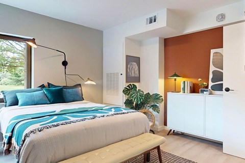 A bedroom with a large bed and a white cabinet.
