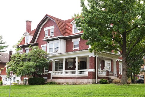 A red brick house with a white porch.