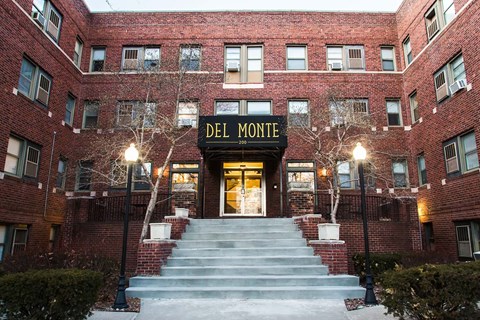The Del Monte building is made of red brick and has a large staircase leading to the entrance.