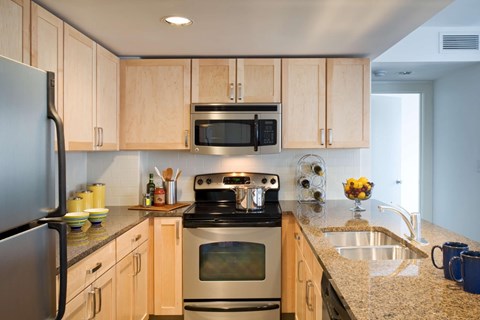 A kitchen with wooden cabinets and a granite countertop.