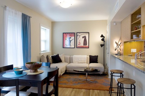 A living room with a couch, a table, and a painting on the wall.