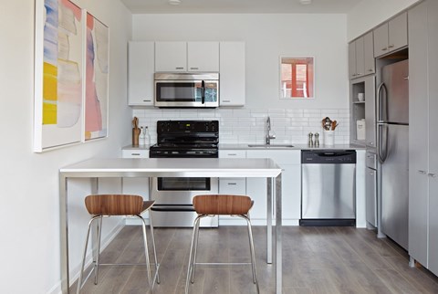 A modern kitchen with a white table and chairs.