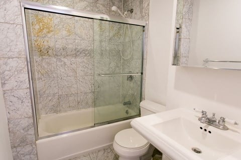 A white toilet sits next to a sink in a bathroom.