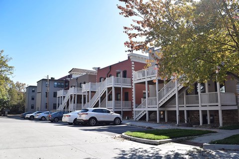 A parking lot with cars and a building with a red roof.