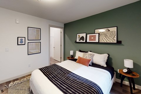 A bedroom with a large bed and a green wall.