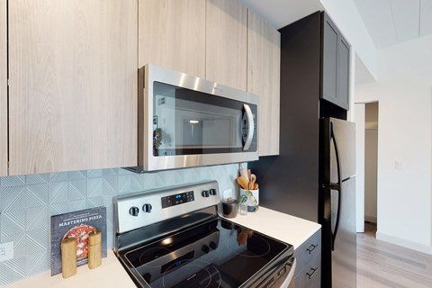 A modern kitchen with a black stove top oven and a black refrigerator.