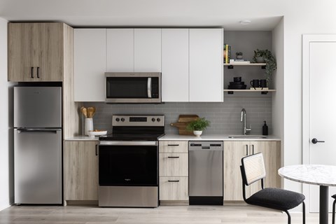 A modern kitchen with a refrigerator, oven, and microwave.
