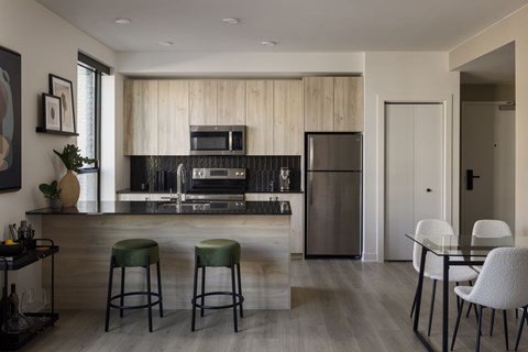 A modern kitchen with a bar area and a dining table.