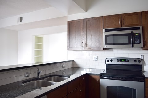 A kitchen with a black oven and microwave.