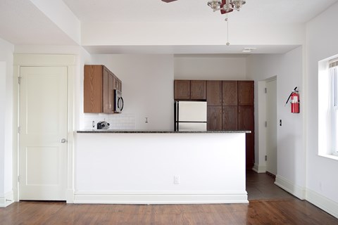 A kitchen with white countertops and wooden cabinets.