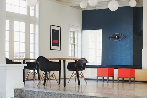 A dining room with a table and chairs.