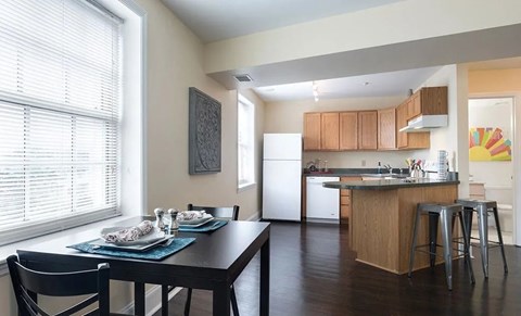A kitchen with a dining table and chairs is shown.