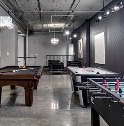 A room with a pool table and a foosball table.