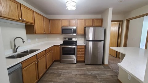 A kitchen with wooden cabinets and stainless steel appliances.
