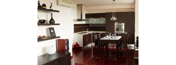 A modern kitchen with dark wood floors and furniture.