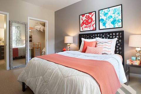 A bedroom with a large bed and two framed pictures on the wall.