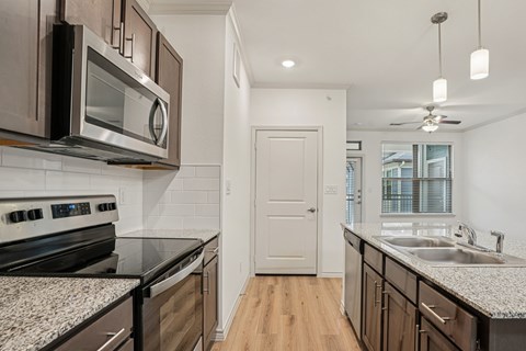 A kitchen with a black counter top and a white door.