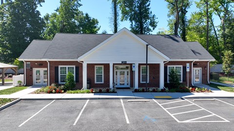 A small building with a parking lot in front.