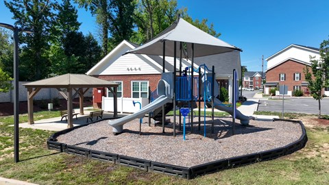 A playground with a slide and a canopy.