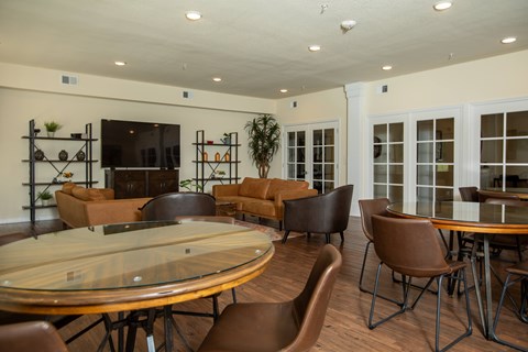 A conference room with a glass table surrounded by chairs.