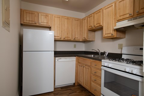 A kitchen with wooden cabinets and white appliances.
