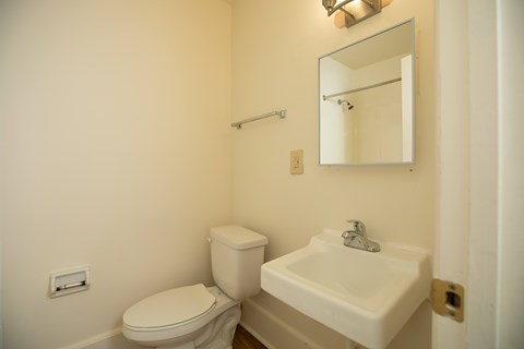 A white toilet and sink in a small bathroom.