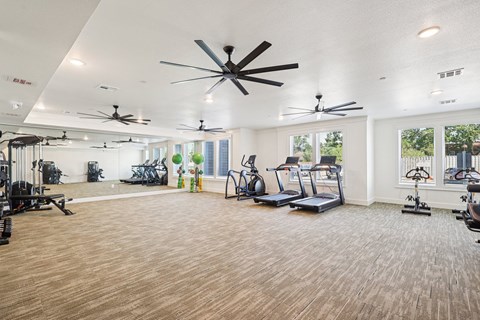 A spacious gym with treadmills, exercise bikes, and a variety of workout equipment.