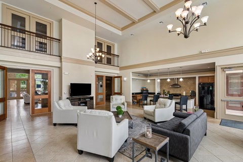A large, well-lit living room with a balcony and a bar area.