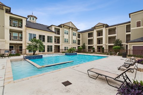 A large swimming pool in front of apartment buildings.
