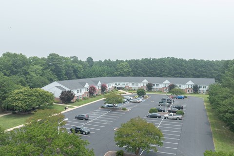 A parking lot with cars and a building in the background.
