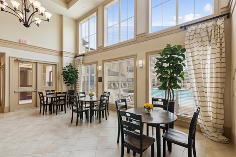 A dining room with a table set for six with a view of the pool outside.