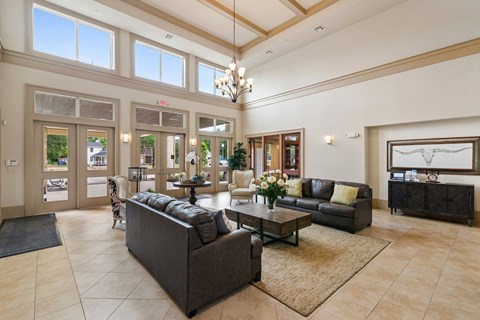 A spacious living room with a large grey sofa and a coffee table.