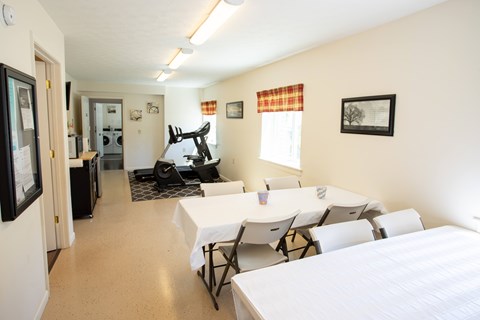 A room with a bed, table and chairs.