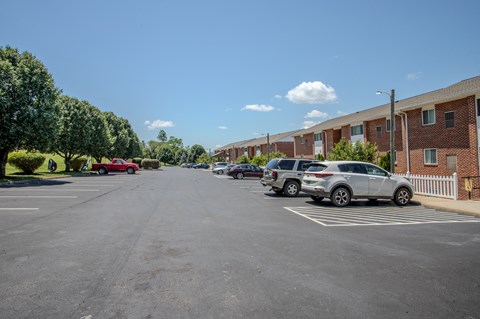 A parking lot with cars and apartment buildings in the background.