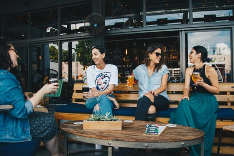 Four people are sitting at a table in a restaurant.