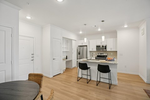 A kitchen with a table and chairs in front of it.