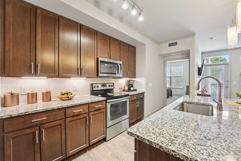 A kitchen with wooden cabinets and granite countertops.