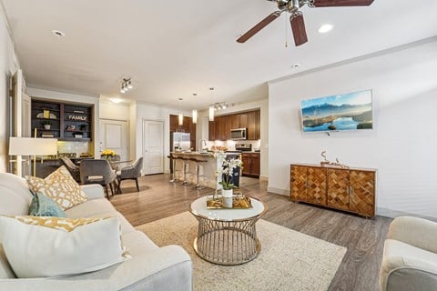 A living room with a white couch and a painting on the wall.