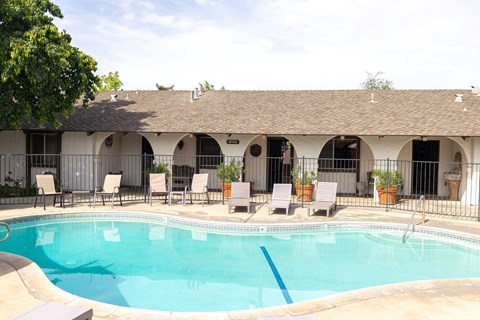 A pool with chairs around it.