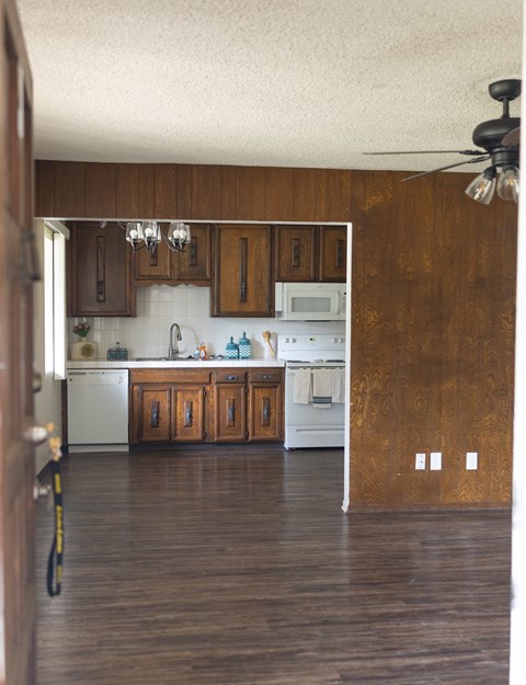 A kitchen with wooden cabinets and a white dishwasher.
