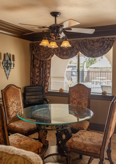A dining room with a glass table and chairs.