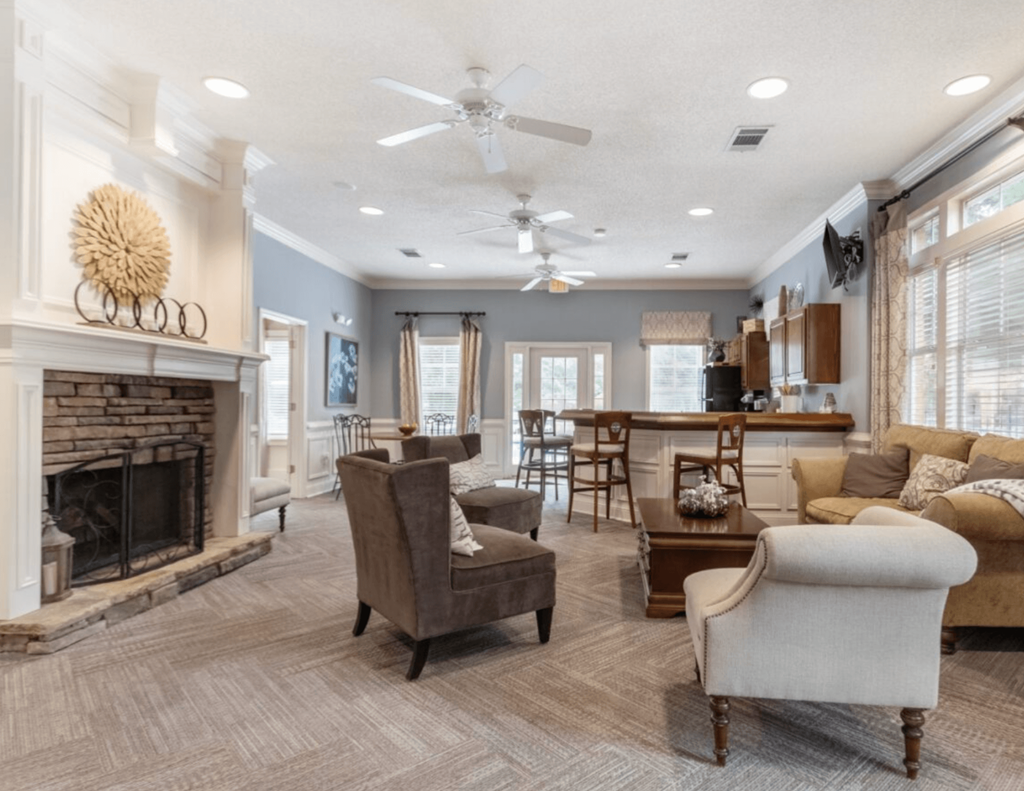 A living room with a fireplace and a ceiling fan.