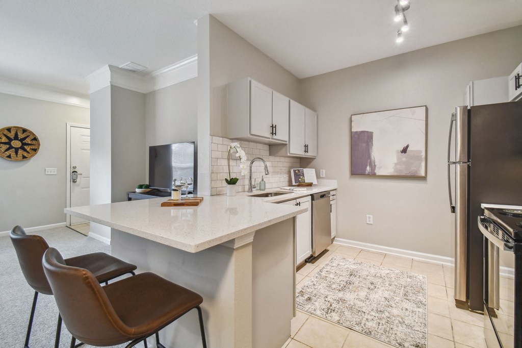 an open kitchen and living room with a marble counter top
