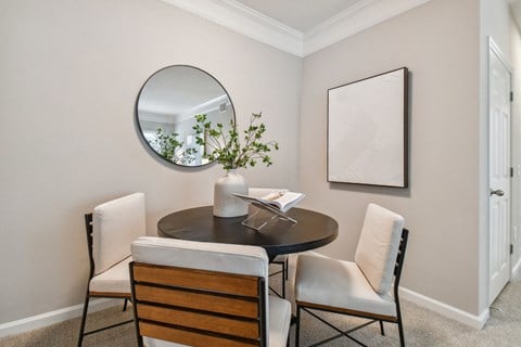 a dining room with a table and chairs and a mirror