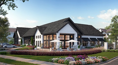 A large white house with a black roof and a garden in front.