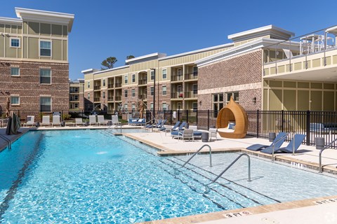 A large swimming pool in front of apartment buildings.