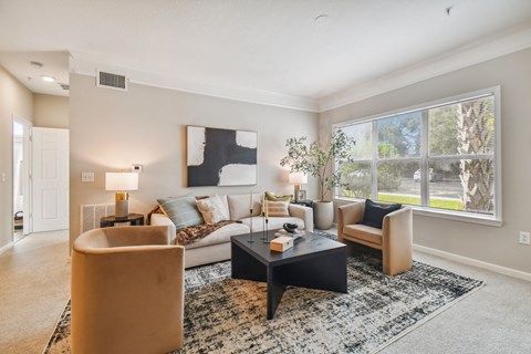 a living room with a couch and a coffee table and a window