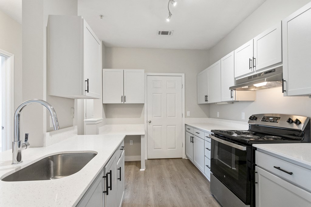 a kitchen with white cabinets and a black stove top oven